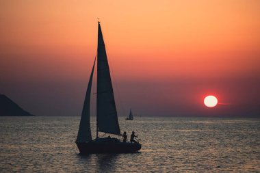 Canlı renkli günbatımı karşı onun yolculuğu boyunca yelken kontrast bir tekne ile yelkenli günbatımı fantezi