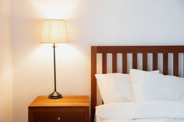 Konforlu, aydınlık yatak odasının içinde eski stil lamba.