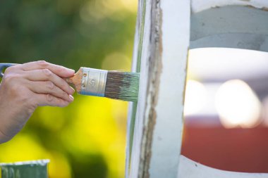 İnsan eli tebeşirle ahşap mobilya boyuyor. Yepyeni renkli tebeşir boyasıyla eski moda ahşap mobilyaları yeniliyorum. Ev dekorasyonu yeniden biçimlendiriliyor