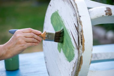 İnsan eli tebeşirle ahşap mobilya boyuyor. Yepyeni renkli tebeşir boyasıyla eski moda ahşap mobilyaları yeniliyorum. Ev dekorasyonu yeniden biçimlendiriliyor