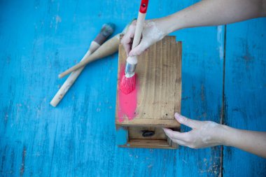 İnsan eli tebeşirle ahşap mobilya boyuyor. Yepyeni renkli tebeşir boyasıyla eski moda ahşap mobilyaları yeniliyorum. Ev dekorasyonu yeniden biçimlendiriliyor