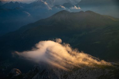 Dolomite dağlarında gün batımı oyunları ve sis Rifugio Lagazuoi 'nin en yüksek tepelerinde görüldü. Muhteşem bir yaz günbatımında..
