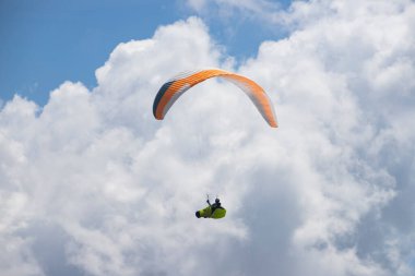 Mavi gökyüzünde bulutlarla uçan paraglider. Macera konsepti..