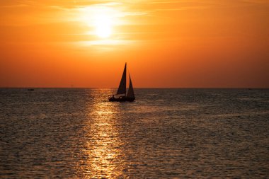 Canlı renkli günbatımı karşı onun yolculuğu boyunca yelken kontrast bir tekne ile yelkenli günbatımı fantezi