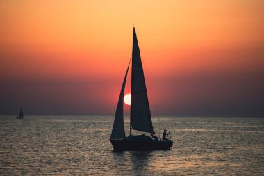 Canlı renkli günbatımı karşı onun yolculuğu boyunca yelken kontrast bir tekne ile yelkenli günbatımı fantezi