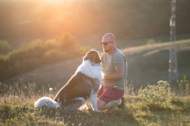 Köpeğine şefkat ve ilgi gösteren mutlu bir adam.