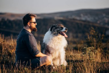 İnsan ve köpeği güzel gün batımının tadını çıkarıyorlar..