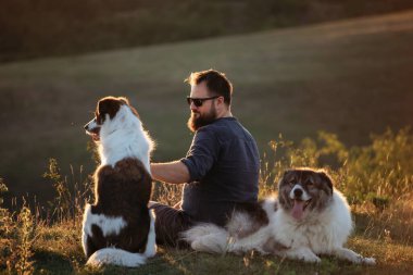 İnsan ve köpekleri güzel gün batımının tadını çıkarıyorlar..