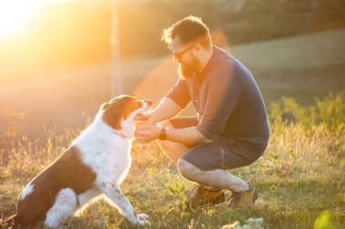 Köpeğine şefkat ve ilgi gösteren mutlu bir adam.