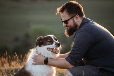 Köpeğine şefkat ve ilgi gösteren mutlu bir adam.