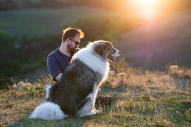 İnsan ve köpeği güzel gün batımının tadını çıkarıyorlar..
