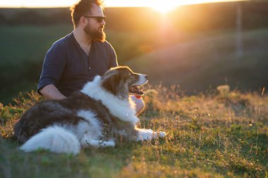 İnsan ve köpeği güzel gün batımının tadını çıkarıyorlar..