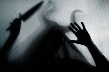 Karanlıkta, pencerenin arkasında elinde bıçak olan ürkütücü bir figür. Cadılar Bayramı geçmişi