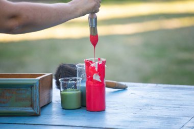 İnsan eli tebeşirle ahşap mobilya boyuyor. Yepyeni renkli tebeşir boyasıyla eski moda ahşap mobilyaları yeniliyorum. Ev dekorasyonu yeniden biçimlendiriliyor