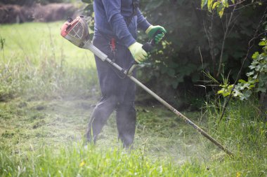 Çim biçme makinesiyle çimleri biçmek. Bahçe işleri konsepti.