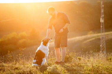Adam itaat eğitiminden sonra köpeğine ödül veriyor..