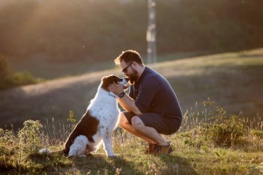 Köpeğine şefkat ve ilgi gösteren mutlu bir adam.