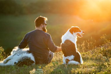 İnsan ve köpekleri güzel gün batımının tadını çıkarıyorlar..