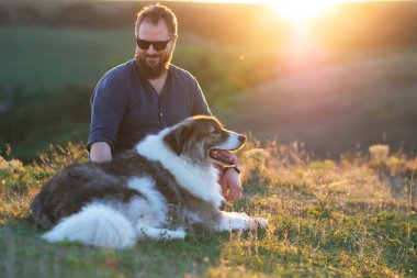 İnsan ve köpeği güzel gün batımının tadını çıkarıyorlar..