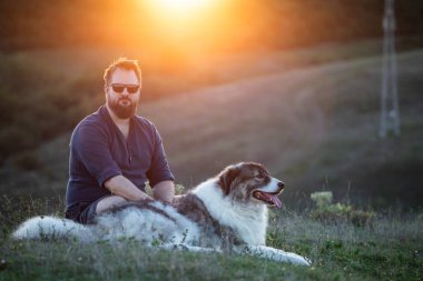 İnsan ve köpeği güzel günbatımının tadını çıkarıyor.