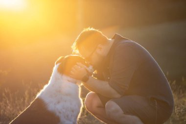 Köpeğine şefkat ve ilgi gösteren mutlu bir adam.