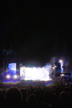 Konserde kalabalık - Parlak renkli sahne ışıkları önünde tezahürat yapan kalabalık