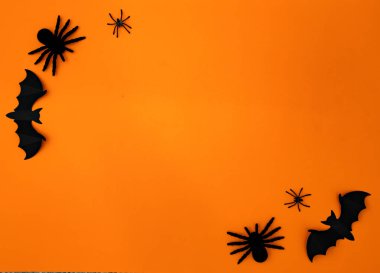 Halloween flat lay composition on orange background with copy space.