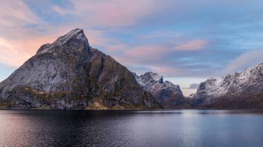 Norveç 'in Lofoten Adaları' nın keskin dağ zirvelerinde günbatımı panoramik manzarası