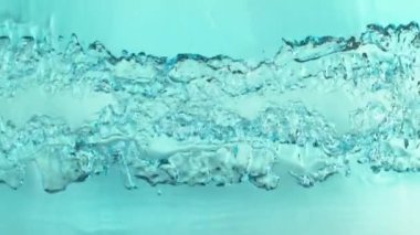 Açık mavi arka planda su yüzeyinin çok yavaş hareket etmesi. 1000 FPS 'de yüksek hızlı sinematik kamera ile çekildi.