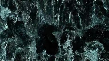 Siyah arka planda su sıçrayan süper yavaş çekim. 1000 FPS 'de yüksek hızlı sinematik kamera ile çekildi.