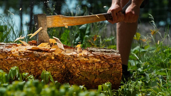 Człowiek Rąbiący Drewniane Kłody Siekierą Lesie — Zdjęcie stockowe