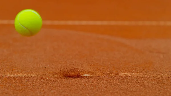 Close up of Tennis ball ping on clay court inside or outside white line