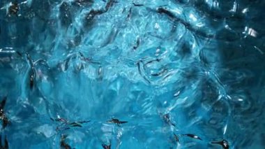 Açık mavi arka planda su yüzeyinin çok yavaş hareket etmesi. 1000 FPS 'de yüksek hızlı sinematik kamera ile çekildi.