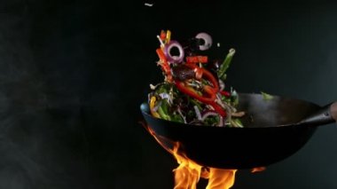 Havada Uçan Malzemeler ve Ateş Alevleri ile Wok Pan 'ın Süper Yavaş Çekimi. Yüksek Hız Sinema Kamerası 'nda 1.000 FPS' de çekilmiştir..