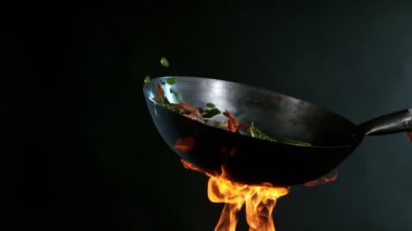 Havada Uçan Malzemeler ve Ateş Alevleri ile Wok Pan 'ın Süper Yavaş Çekimi. Yüksek Hız Sinema Kamerası 'nda 1.000 FPS' de çekilmiştir..