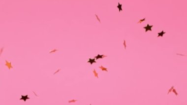 Pembe Arkaplanda Altın Yıldızlar Düşüyor. Süper Yavaş Hareket, 1000 FPS.