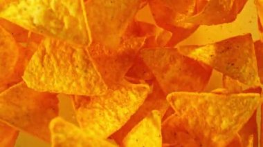 Renk eğimli arka planda uçan tortilla cipslerinin süper yavaş çekimi. Yüksek hızlı sinema kamerası, 1000 fps. Kamera yüksek hızlı sinüs robotuna yerleştirildi, hedefi takip ediyor..