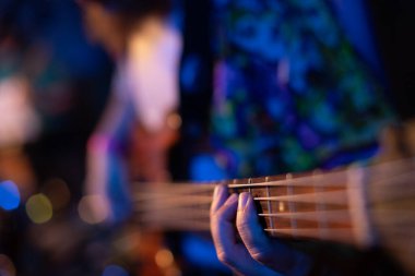 Bas gitarist ya da gitarist müzik enstrümanı çalıyor.