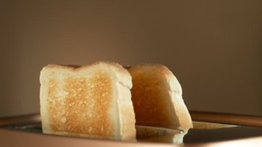 Bronz Gradyan Arkaplan 'da tost makinesinden fırlayan Çıtır Altın Tostlar. Süper Yavaş Film Yüksek Hız Sinema Kamerası 'nda 1000 FPS' de çekildi.