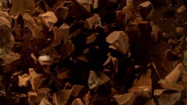 Çikolata parçaları uçarken uçar ve dönüşümlü olarak uçar. Üst Manzara. Film yavaş çekimde 1000 fp..