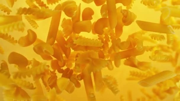 Super Hidas Lentäminen Kypsentämätön Italialainen Pasta Penne Kultaisella Taustalla Kuvattu — kuvapankkivideo