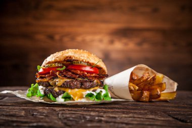 Eski ahşap masada marul ve peynirli ev yapımı hamburger.