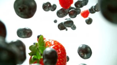 Düşen ve dönen böğürtlenleri beyaz arka planda gösteren süper yavaş çekim. 1000 fps hızla yüksek hızlı sinematik kamera ile çekildi..