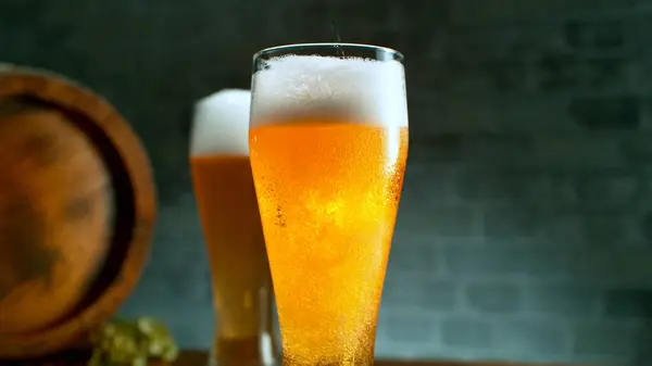 Freshly brewed beer in a pint on grey brickwall background, close-up