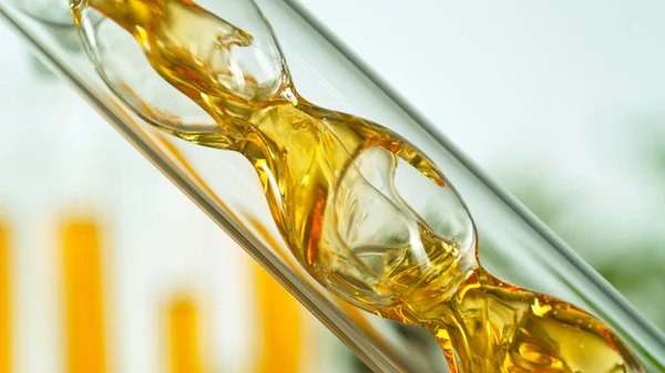 Getting natural oil from natural substances and flowers. Yellow oil flows in a spiral.