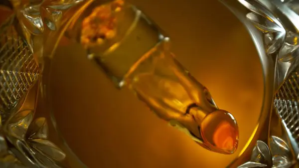 フリーズモーションショット ウイスキー液体注ぐ マクロ ガラスの底からの眺めのユニークな角度 — ストック写真
