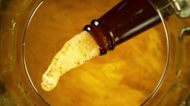 Şişeden Pint 'e dökülen biranın Süper Yavaş Çekimi, Bardağın altından benzersiz Bakış açısı