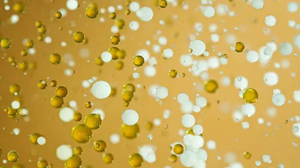 Freeze Motion Shot Moving Oil Milk Bubbles Golden Background Cosmetics — Stock Photo, Image