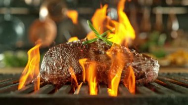 Lezzetli bifteği şömine ızgarasına yakın çekim, ateş alevleri, süper yavaş çekim, yüksek hızlı sinematik kamera ile 1000 fps. Kamera hareketi.