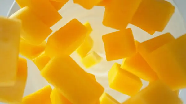 新鲜的芒果块掉进酸奶油 俯瞰全景 免版税图库图片